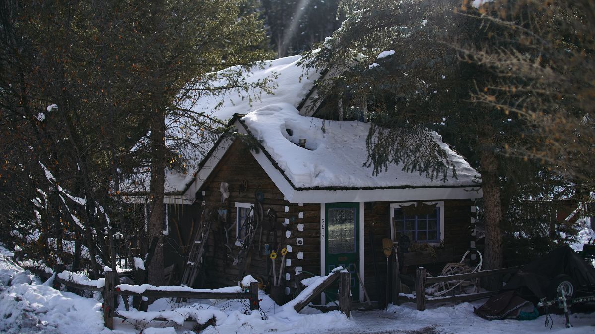 A small house blanketed in snow, highlighting the importance of roof protection from winter weather in Illinois.