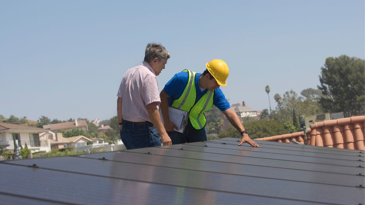 Two professionals inspect a roof during winter, highlighting the importance of roof maintenance for Illinois homes.